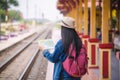 Young asian gril walking at train station before travel. work and travel concept