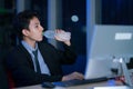 Young asian handsome business man drinking water after work hard in office at night, businessmen relax after working, business Royalty Free Stock Photo