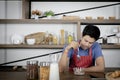 Young Asian handsome man feels stressed and bored while eating, having breakfast meal on wooden table in kitchen room Royalty Free Stock Photo