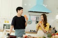 Young asian happy active family couple dancing laughing together preparing food at home, carefree joyful husband and wife having Royalty Free Stock Photo