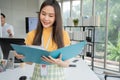 Young Asian Happy Businesswoman or intern holding documents in Modern Office background is Colleagues discuss with new startup Royalty Free Stock Photo