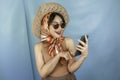 Young Asian happy woman pointing and smiling to her smartphone isolated by a blue background Royalty Free Stock Photo