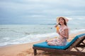 Asian happy woman wearing sun hat holding orange juice relaxing on chair at the beach with happily Royalty Free Stock Photo