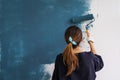 Young asian happy woman painting interior wall