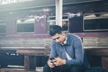 Young asian hipster man holding mobile phone using app song with Royalty Free Stock Photo
