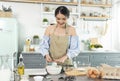 Young Asian housewife in kitchen cooking the bakery dough homemade Royalty Free Stock Photo