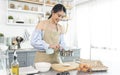 Young Asian housewife in kitchen cooking the bakery dough homemade Royalty Free Stock Photo