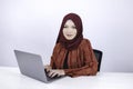Young Islam woman is sitting enjoy and smiling when working on laptop on white background