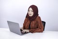 Young Islam woman is sitting enjoy and smiling when working on laptop on white background