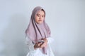 Young Asian Islam woman wearing headscarf is shocked disgusted and angry in what she see on the smartphone. Indonesian woman on Royalty Free Stock Photo