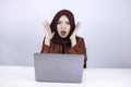 Young Islam woman wearing headscarf is shocked and excited with what she see on laptop on the table