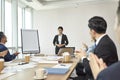 Young asian junior executive delivering a presentation during team meeting Royalty Free Stock Photo