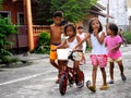 Young asian kids playing and riding a bike