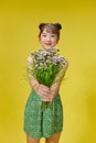 Young asian lady holds bouquet on yellow background Royalty Free Stock Photo