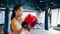 Young Asian lady kickboxing exercise workout punch doing shadow female fighter practice boxing in gym fitness class. Sportswoman