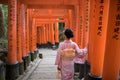 Young Asian Lady in Kimono walking along the inari in Fushimi Inari-taisha, Kyoto, Japan