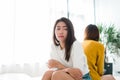 Young Asian lesbian couple argue and turn their back to each other in the period of sad in the bedroom. Royalty Free Stock Photo