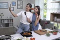 Young Asian lesbian couple looking happy while cooking and taking selfie. LGBT couple preparing meal salad in the kitchen at home Royalty Free Stock Photo