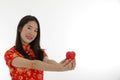 The young asian little woman wearing Chinese traditional dress holding small red heart Valentine