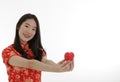 the young asian little woman wearing Chinese traditional dress holding small red heart Valentine