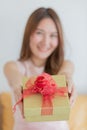 A young asian long brown hair female wearing sleeveless dress receive the gift box with red ribbon from his boyfriend Royalty Free Stock Photo