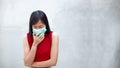 Young Asian woman wearing an anti-virus mask is coughing and sick