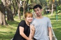 Young Asian love couple relax after an excercise in the park by playing to each other with emotion of love in warm afternoon. Royalty Free Stock Photo