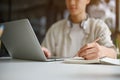 A young Asian male college student sits in the coffee shop doing homework, using laptop Royalty Free Stock Photo