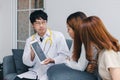 Young Asian male doctor consulting patient in hospital office. Health care and medical concept Royalty Free Stock Photo