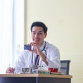 Young male doctor smiles showing credit card on desk in a hospital