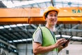 Young Asian male factory worker holding a digital tablet