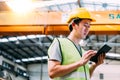 Young Asian male factory worker using a digital tablet