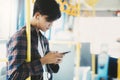 Young asian male passenger using mobile phone on public bus Royalty Free Stock Photo