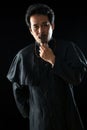 Young Asian male Priest with black uniform holding crucifix rosary