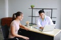 Young Asian male psychiatrist is specialist in psychiatry Caucasain female Patient serious together for therapy and talking for Royalty Free Stock Photo