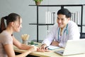 Young Asian male psychiatrist is specialist in psychiatry Caucasain female Patient serious together for therapy and talking for Royalty Free Stock Photo