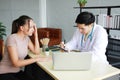 Young Asian male psychiatrist is specialist in psychiatry Caucasain female Patient serious together for therapy and talking for Royalty Free Stock Photo