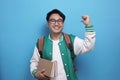 Young Asian male student smiling and pointing presenting something behind him, marketing concept Royalty Free Stock Photo