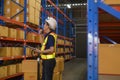 Young asian male worker wearing helmet using talki walki in modern warehouse