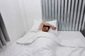 Young Asian man with blindfold eye mask sleeping on the white bed in bedroom