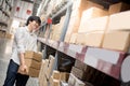 Young Asian man carrying paper boxes in warehouse Royalty Free Stock Photo