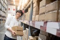 Young Asian man carrying paper boxes in warehouse Royalty Free Stock Photo