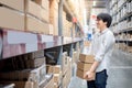 Young Asian man carrying paper boxes in warehouse Royalty Free Stock Photo