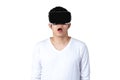 Young asian man in casual white outfit holding or wearing VR glasses watching video Royalty Free Stock Photo