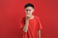 Young Asian man close his nose for bad smell, on red color Royalty Free Stock Photo
