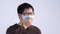 Young Asian man is coughing, feeling unwell, vomit sick with wearing a medical blue face mask  on white background, close Royalty Free Stock Photo