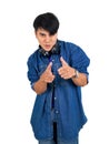 Young asian man dress in jean with headphone pointing finger in front direction. Portrait on white background with studio light. Royalty Free Stock Photo