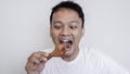 Young Asian man is eating fried chicken wear white shirt Royalty Free Stock Photo