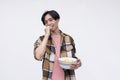 A young asian man eating popcorn in a relaxed casual way while watching a movie. Isolated on a white background Royalty Free Stock Photo