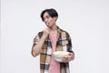 A young asian man eating popcorn in a relaxed casual way while watching a movie. Isolated on a white background Royalty Free Stock Photo